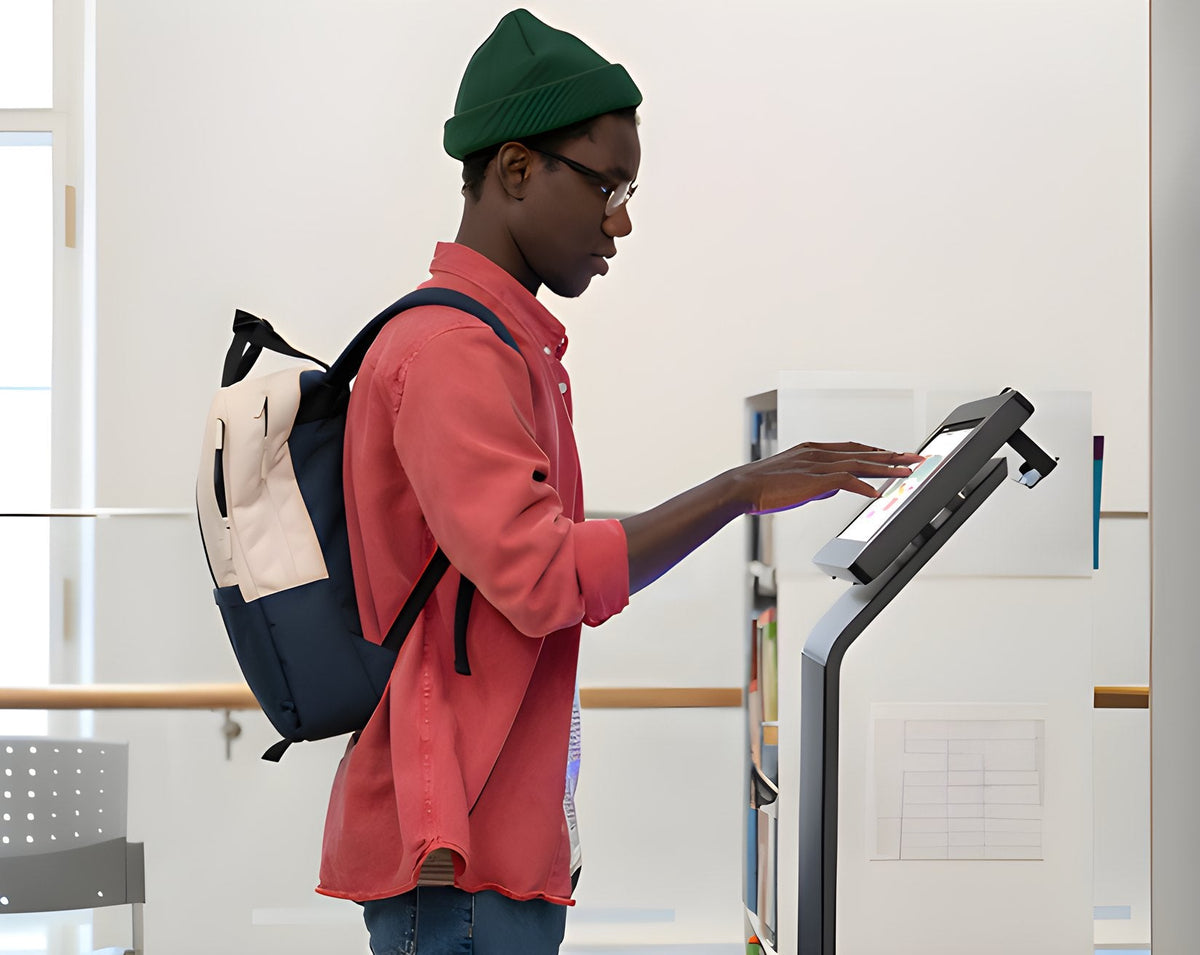 Student with a backpack using a check-in tablet on a floor stand