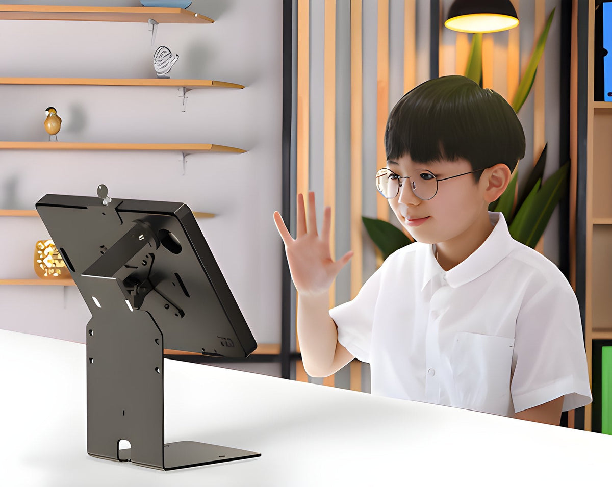 Student arriving at a tabletop check-in tablet and waving